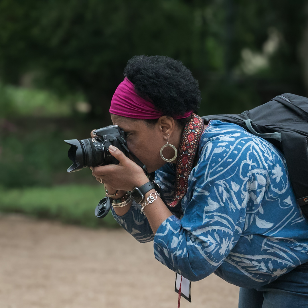 Tanya with pink headband and blue shirt photographing plants at Lady Bird Wildflower Center